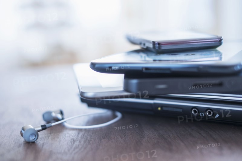 Close up of stack of devices on desk.