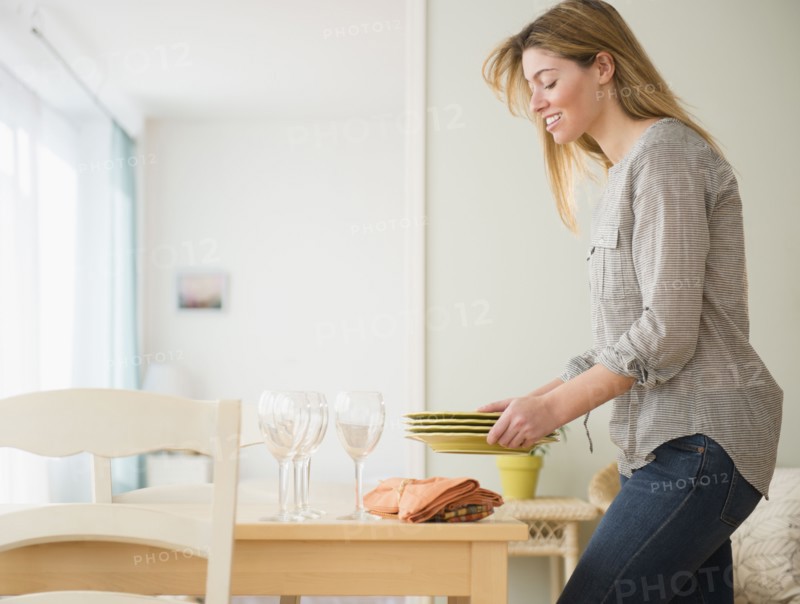 Young woman setting table.
Photo : Jamie Grill