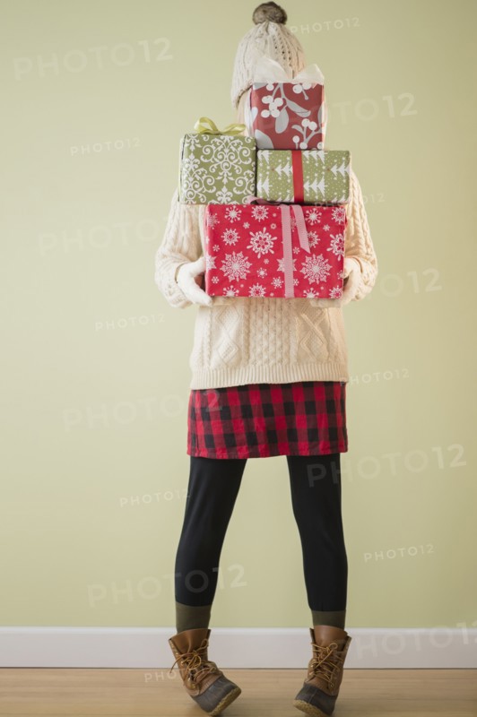Woman holding stack of presents.
Photo : Jamie Grill