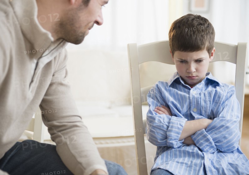 Father looking at displeased son (8-9) .
Photo : Jamie Grill