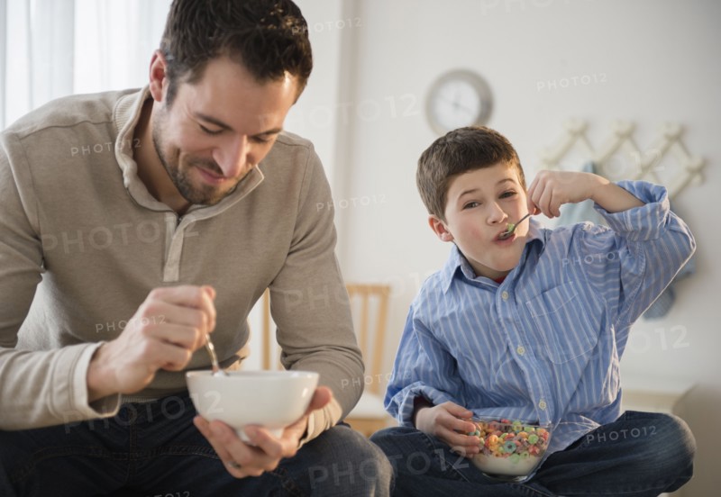 Father and son (8-9) eating breakfast cereal.
Photo : Jamie Grill