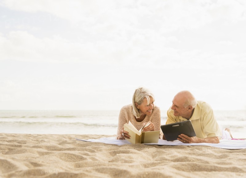 Senior couple reading books on beach.
Photo : Daniel Grill