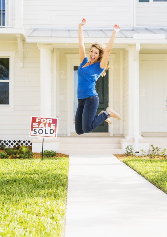 Woman jumping in front of new house.
Photo : Daniel Grill