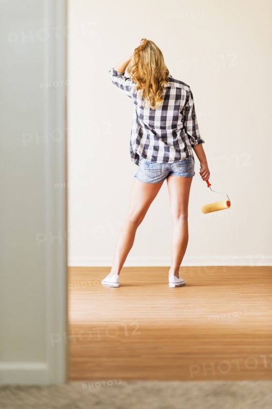 Rear view of woman holding paint roller.
Photo : Daniel Grill