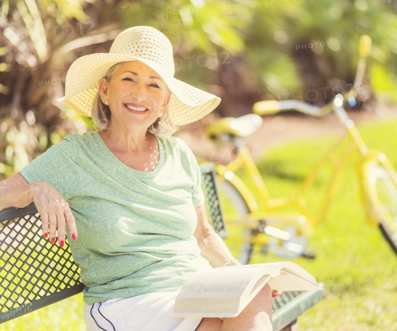 Portrait of senior woman reading book in park.
Photo : Daniel Grill