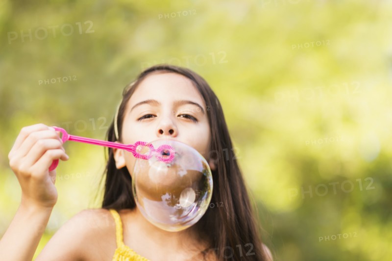 Portrait of girl (8-9) blowing bubbles.
Photo : Daniel Grill
