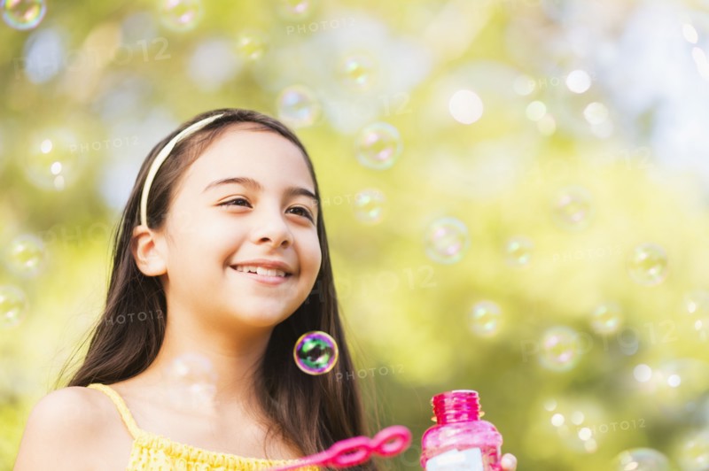 Portrait of girl (8-9) blowing bubbles.
Photo : Daniel Grill