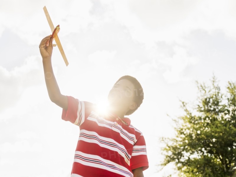 boy (6-7) playing with toy airplane.
Photo : Daniel Grill