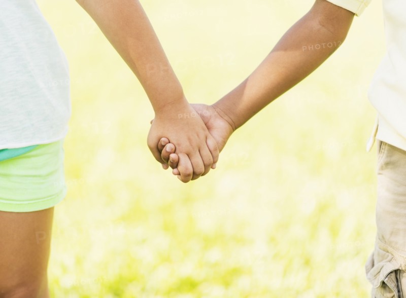 girl ( 8-9) and boy (6-7) holding hands, close up.
Photo : Daniel Grill