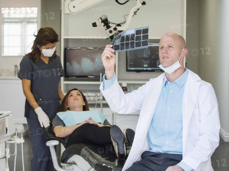 Dentist looking at x-ray.
