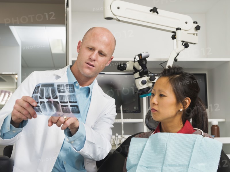 Dentist holding patient's x-ray.