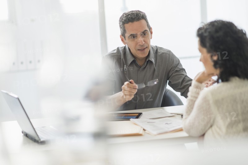 Business people talking at desk in office.