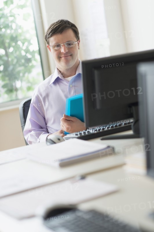 Man with down syndrome working in office.