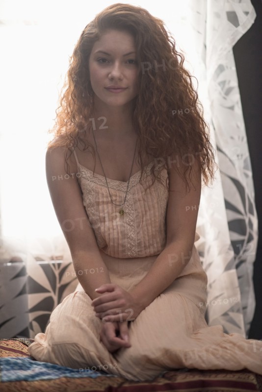 Portrait of stylish woman in window sill.