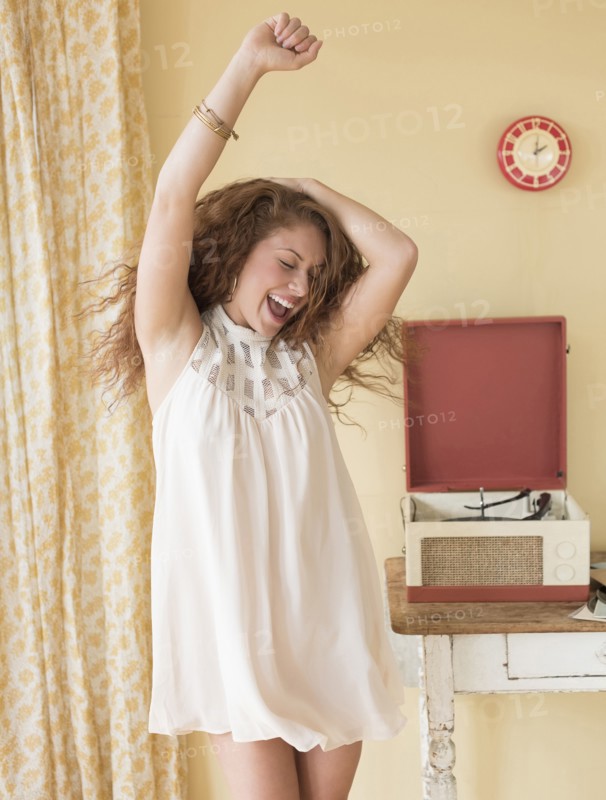 Portrait of woman dancing happily in room.
