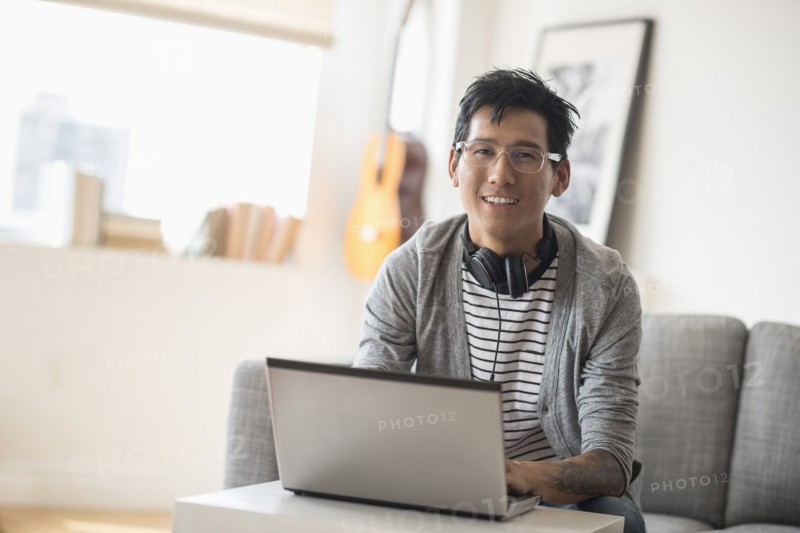 Portrait of man with headphones in front of laptop.