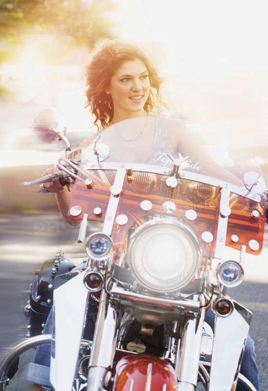 Young woman riding motorcycle.
