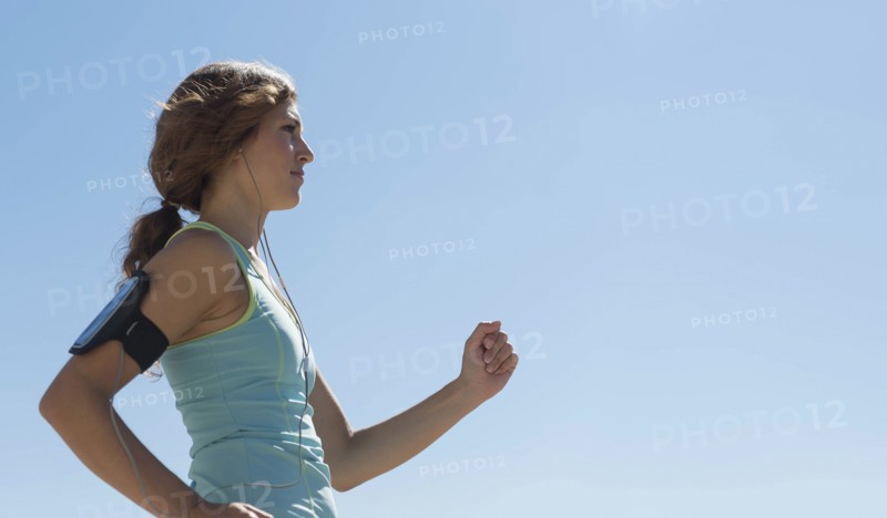 Side view of young woman jogging.