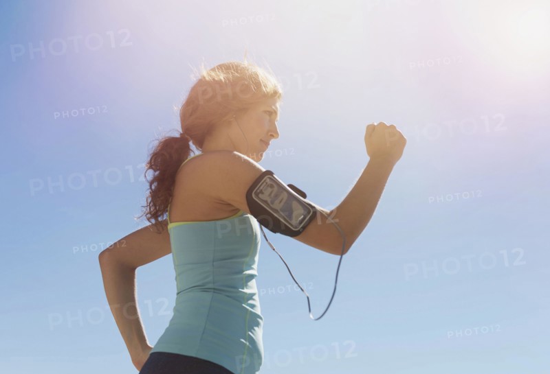 Side view of young woman power walking.