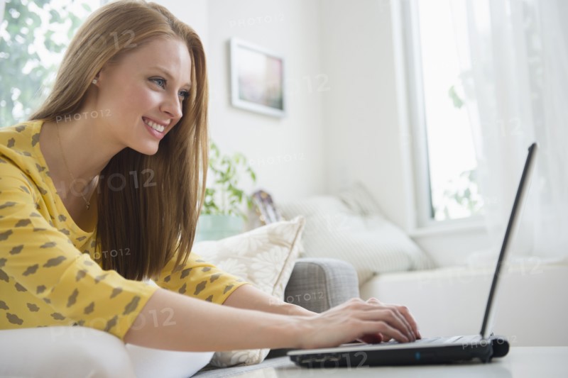 Young woman using laptop in living room