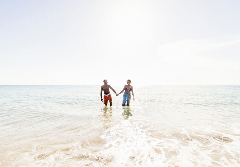 Man and woman holding hands on beach