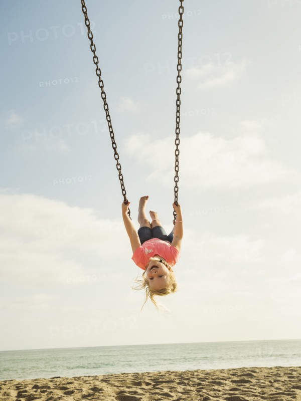Girl (4-5) swinging on beach