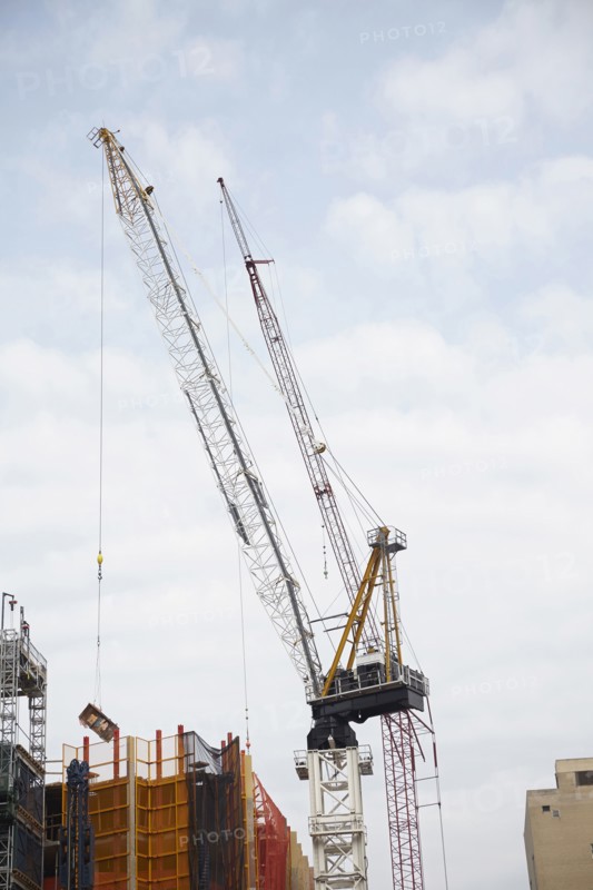 Cranes against cloudy sky