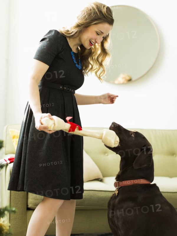 Young woman giving to dog Christmas present