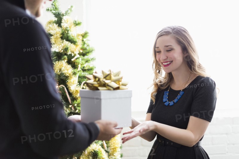 Man giving present to woman at Christmas