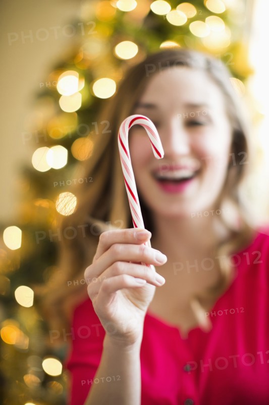 Young woman holding candy cane