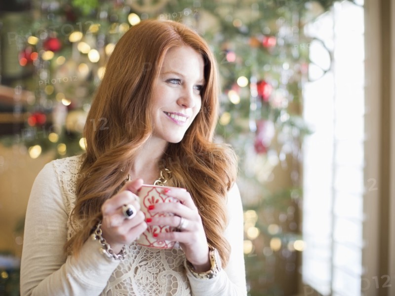 Mid adult woman with coffee mug in christmas time
