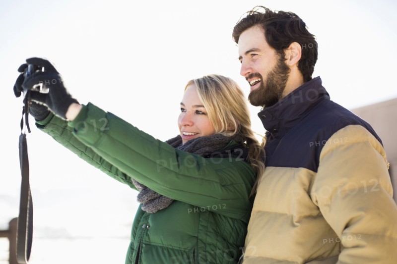 Woman photographing herself and man
