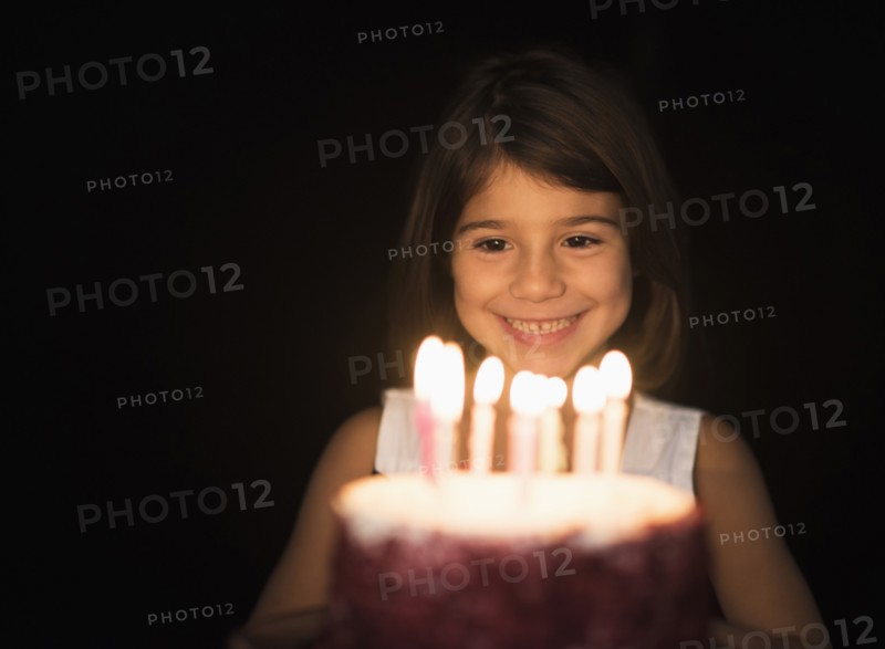Portrait of girl (6-7) with birthday cake.