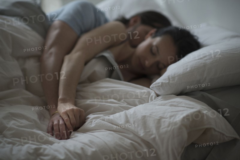 Couple sleeping together in bed at night.