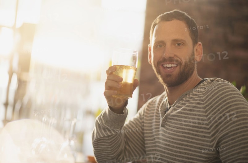 Portrait of man having drink in bar.