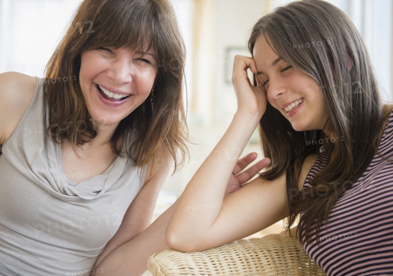 Portrait of mom and teenage girl (14-15) laughing at home