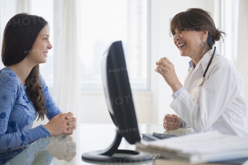 Doctor talking with teenage patient (14-15)