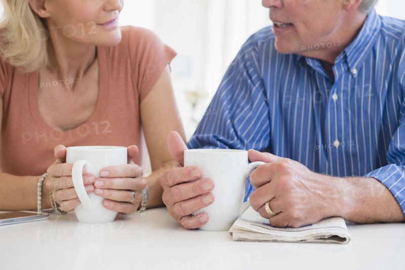 Cropped shot of husband and wife drinking coffee and talking
