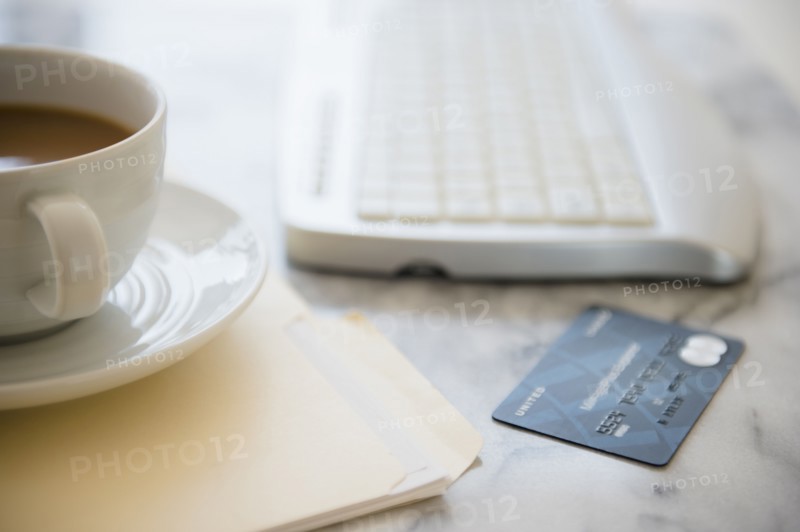 Studio shot of coffee cup, computer keyboard, files and credit card