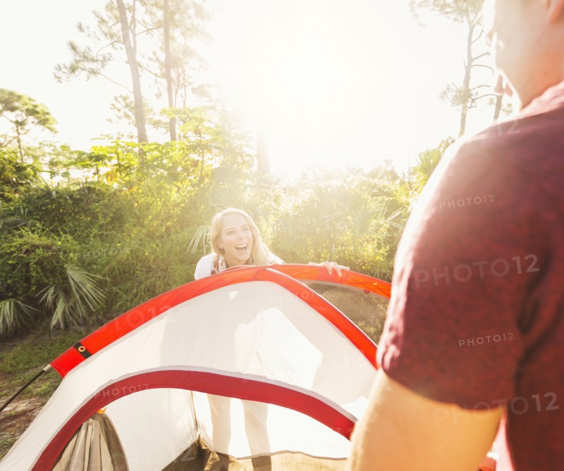 Couple setting up tent in forest