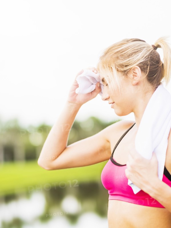 Woman whipping sweat off forehead
