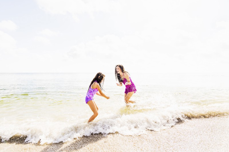 Girl (6-7) and her mom enjoying themselves on beach