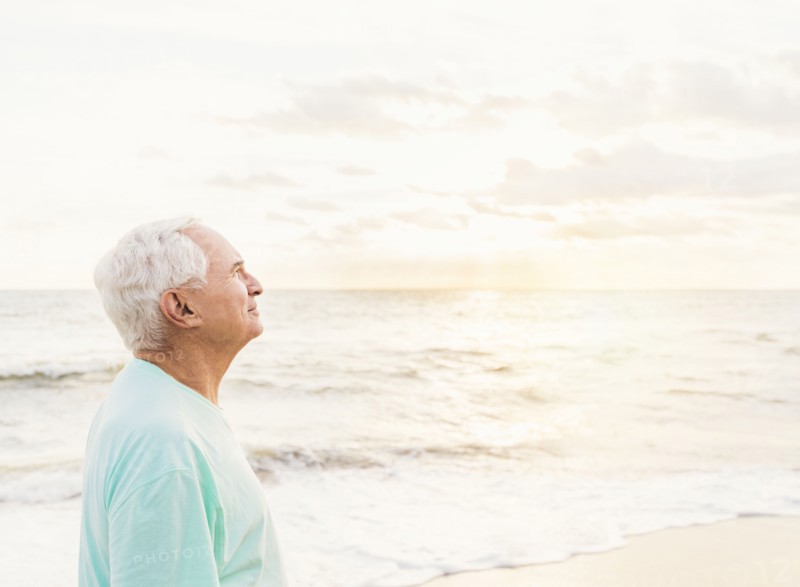 Side view of senior man smiling on beach