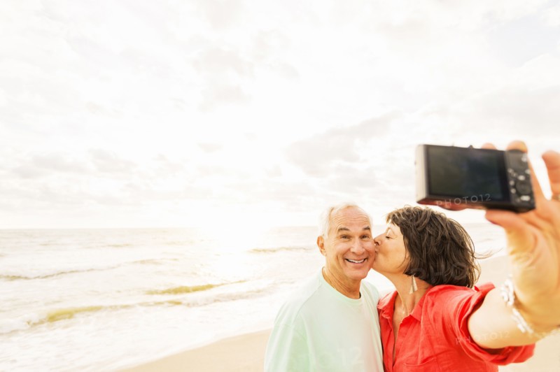 Couple taking selfie on beach at sunrise