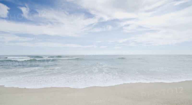 Seascape with surf on sandy beach