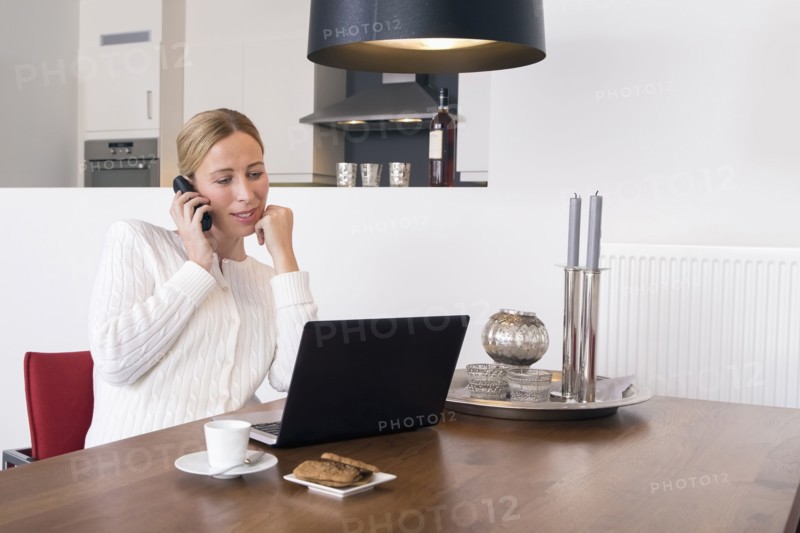 Smiling woman using laptop at home