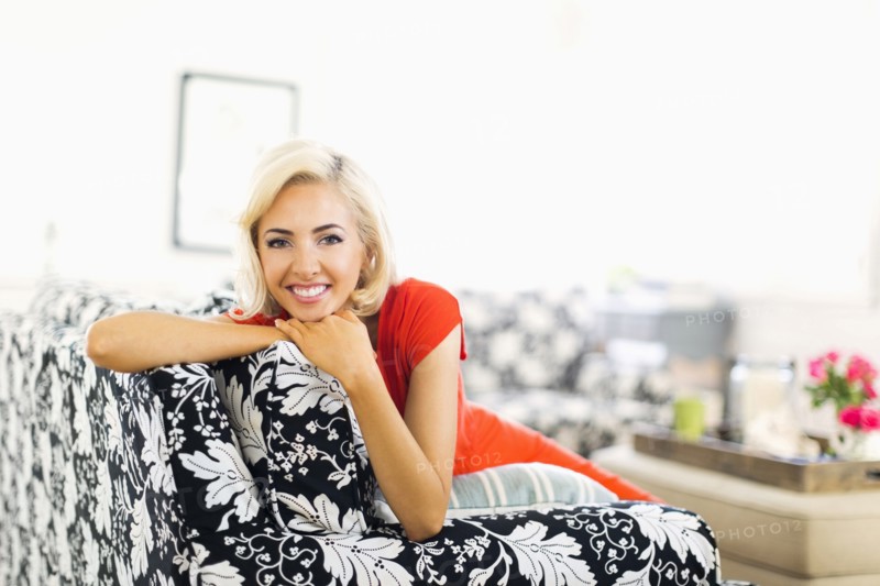 Woman lying down on sofa and smiling to camera