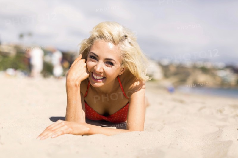 Portrait of blond woman lying on beach