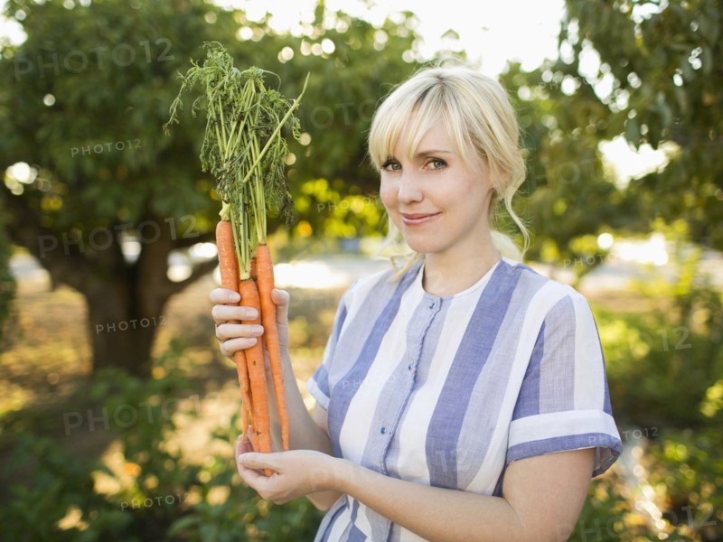 Woman wearing striped dress working in vegetable garden