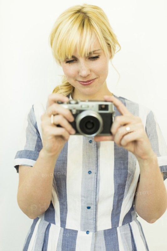 Studio shot of woman holding camera